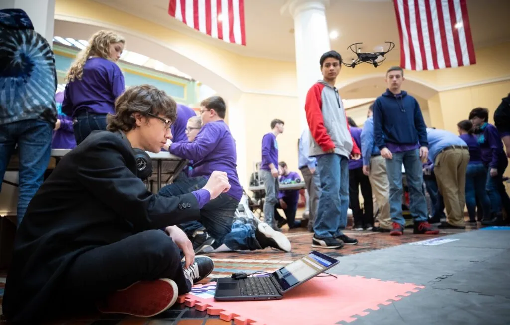 A student flying a drone sitting on the floor at the PA Capitol Building for a PASmart STEM event with II4T